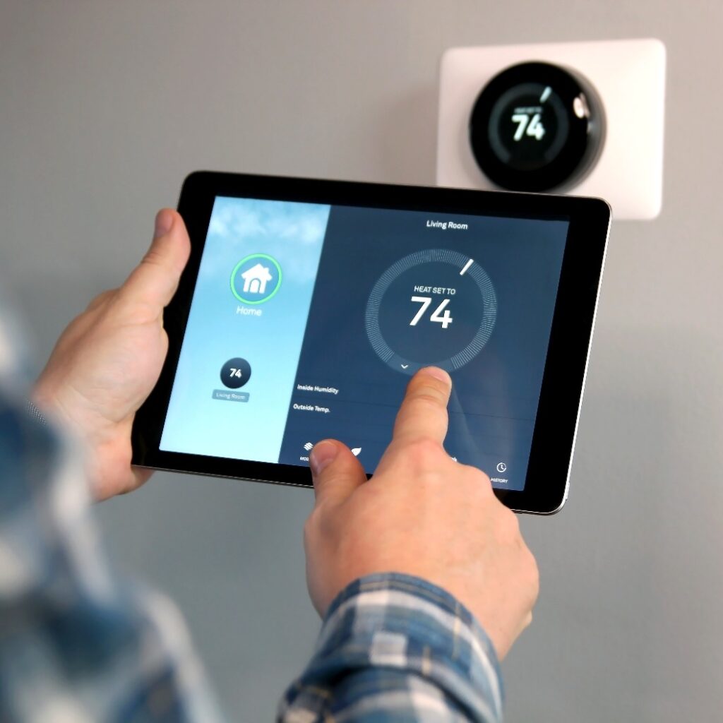 Der Mann reguliert die Temperatur mithilfe eines Tablets mit Smart-Home-Funktion.