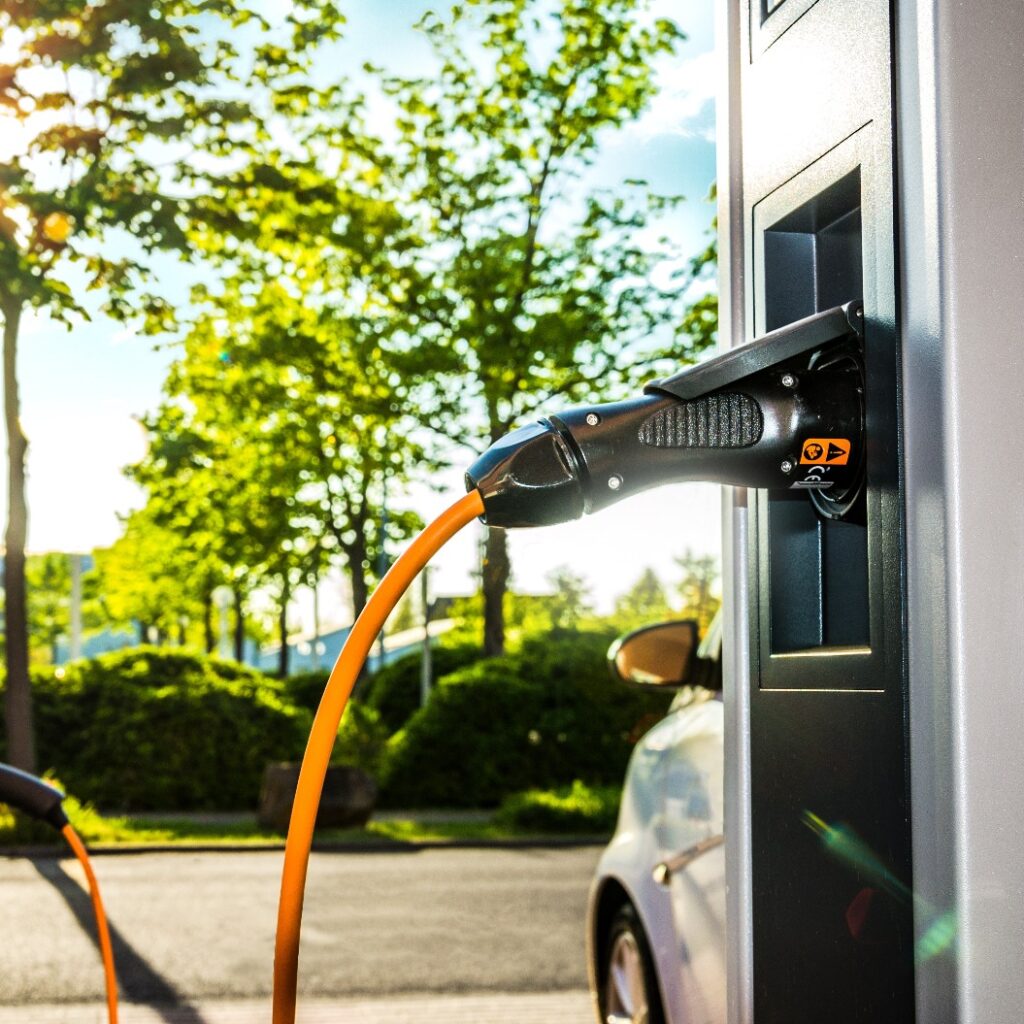 Elektroautos an Ladestation auf Firmengelände im Gegenlicht – Electric Car at Charging Station