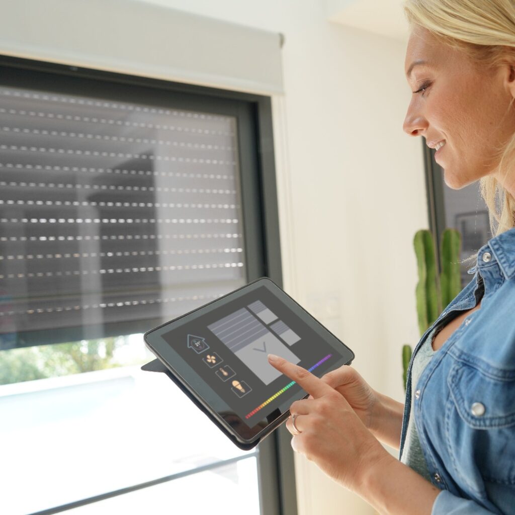 Frau zu Hause bei der Nutzung eines Smart Screens und eines automatisierten Haussystems