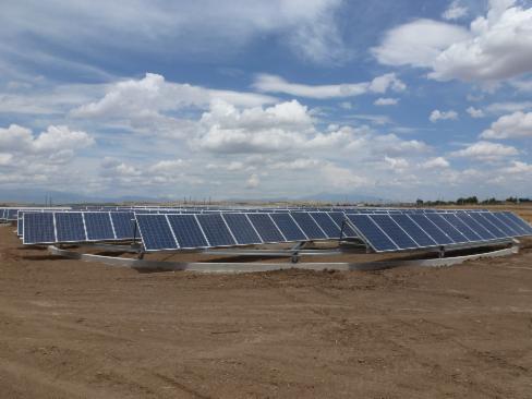 Solaranlage steht auf braunem Erdboden unter blauem Himmel mit weißen Wolken