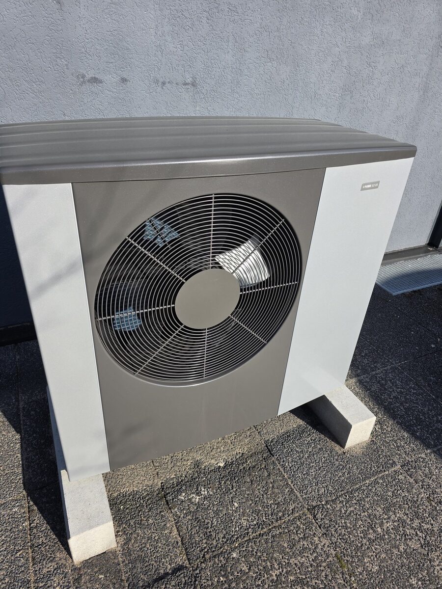 Graue und weisse Aussenklimaanlage mit grossem Ventilatorgitter, sachlich